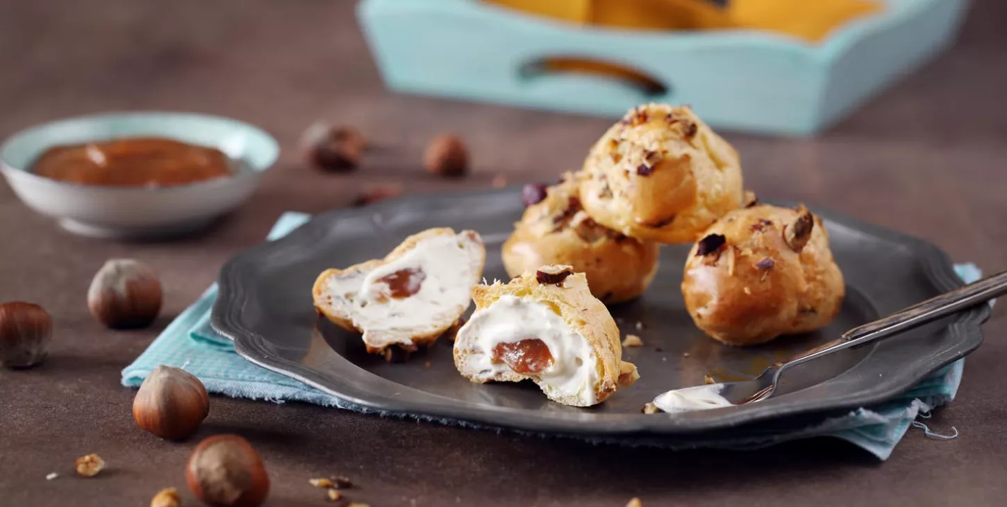 Choux buns with cream, hazelnuts and a caramel centre